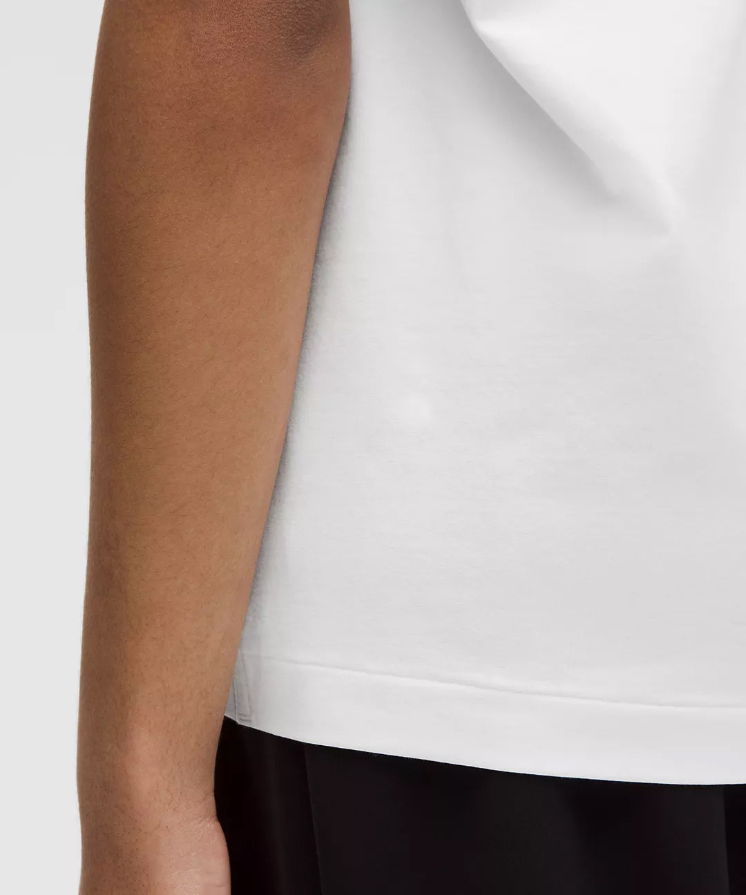 Close-Up of Natural Gas White T-Shirt Hem and Side Stitching on Woman – Minimalist Streetwear Detail Shot for Women's Lifestyle Apparel