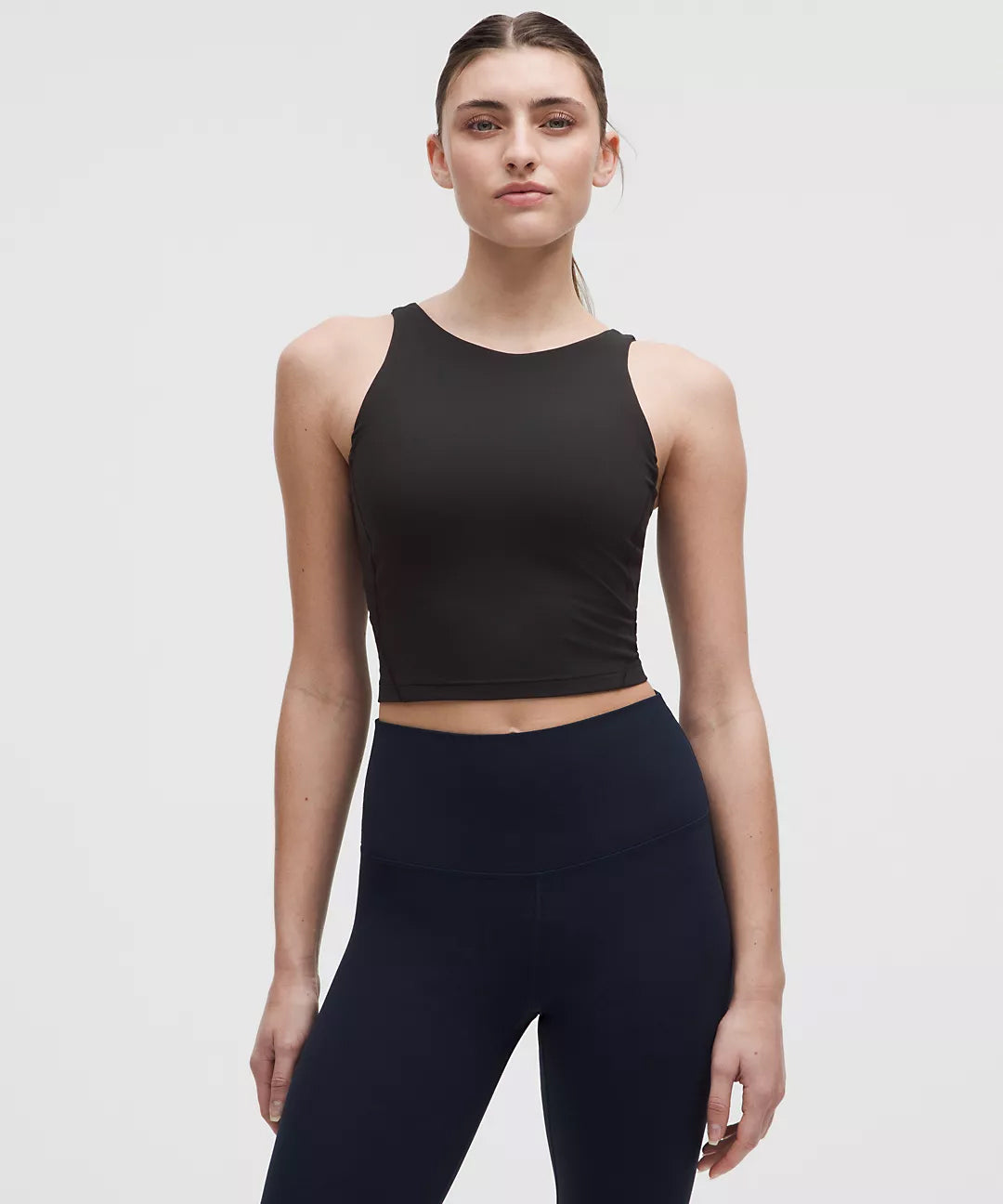 Front View of Woman Wearing Black Natural Gas Tank Top – High-Neck Crop Design – Sleek and Fitted for Athletic Lifestyle