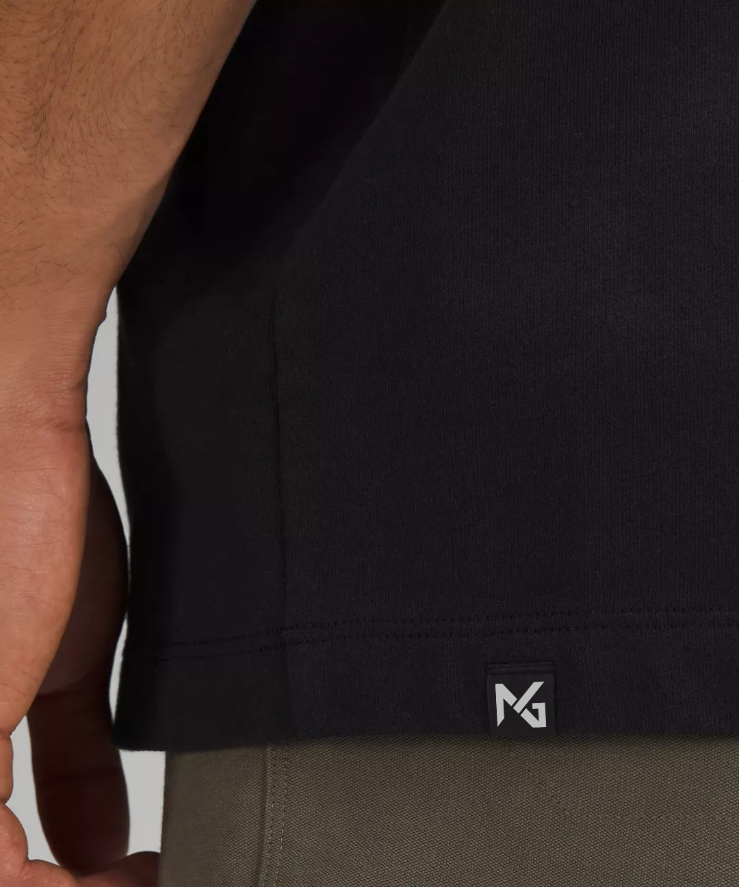 Close-Up of Natural Gas Men’s Black Performance Tee Showing NG Logo Tag Near Hem