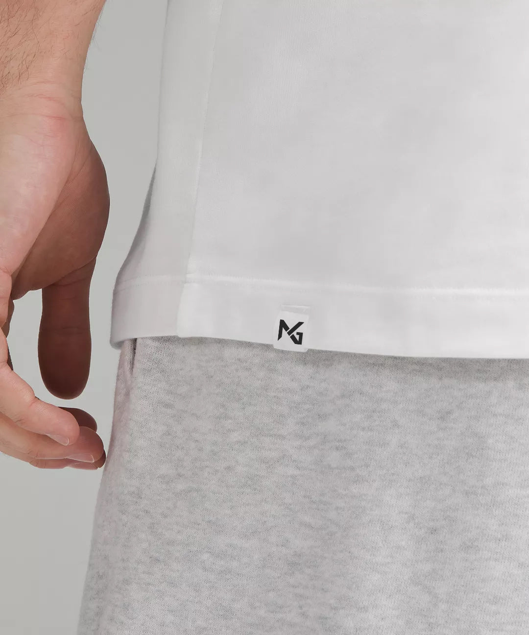 Close-Up of Natural Gas Men’s White Performance Tee with NG Logo Tag Above Hem