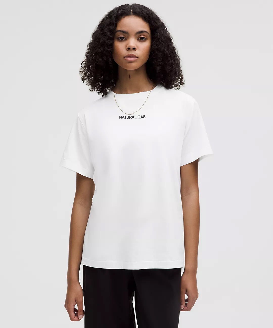 Woman Wearing White Natural Gas T-Shirt with Minimal Front Logo – Clean Lifestyle Streetwear for Women – Modern Relaxed Fit Tee in White with Black Text