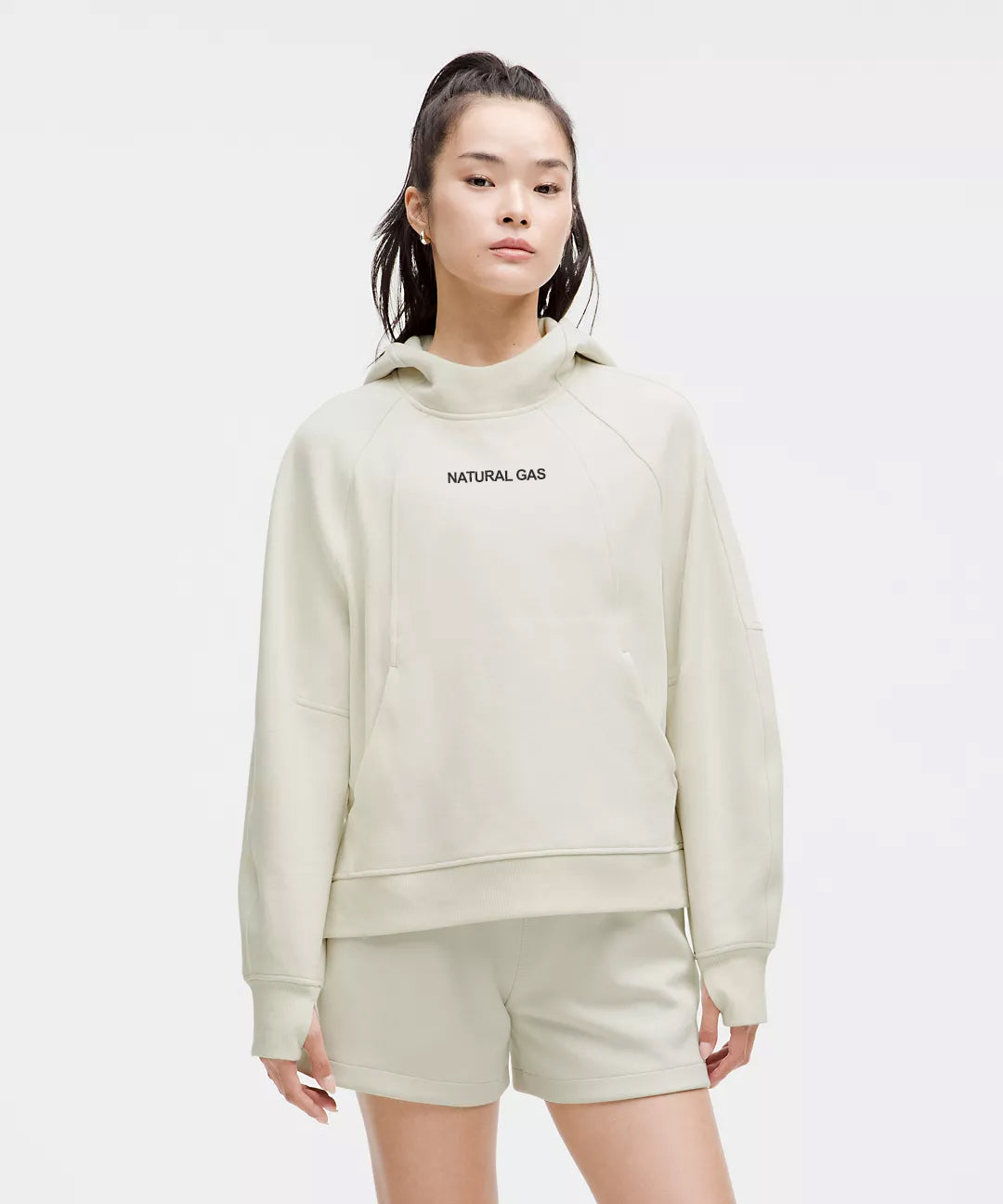 Front View of Woman Wearing Off-White Natural Gas Hoodie and Shorts – “Natural Gas” Text on Chest – Minimalist Lounge and Streetwear Look